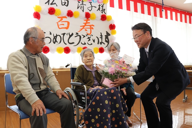 福島健康部長から花束を受け取る清子さん