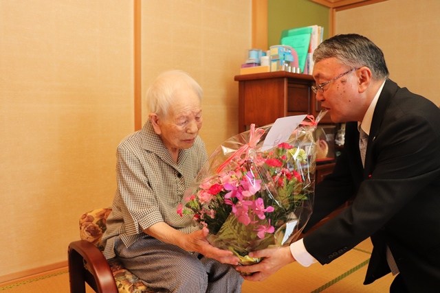 岡野副市長から花かごを受け取るせつさん