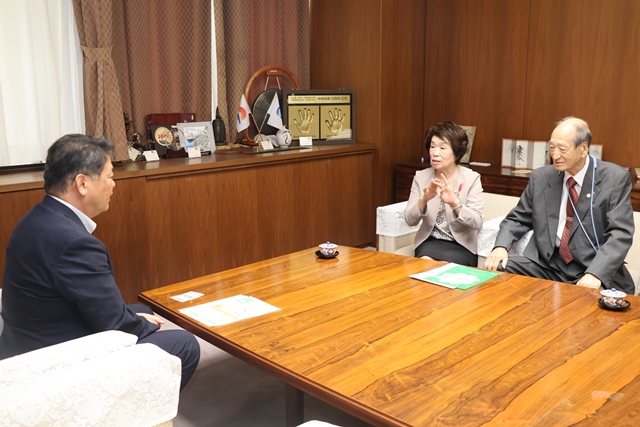 ピンバッジの着用を依頼する守さんと井上さん