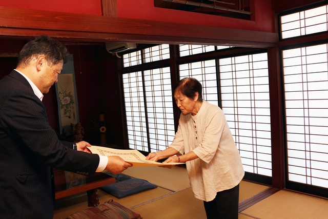叙勲を受け取る助男さんの妻ふじ子さん