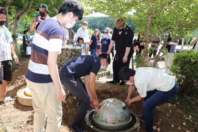 タイムカプセルを掘り起こす参加者