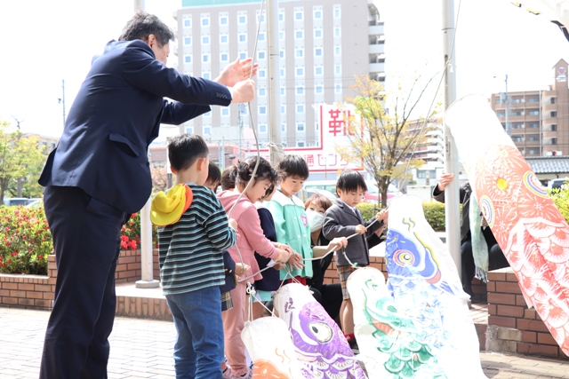 こいのぼりを揚げる茶谷市長と子どもたち