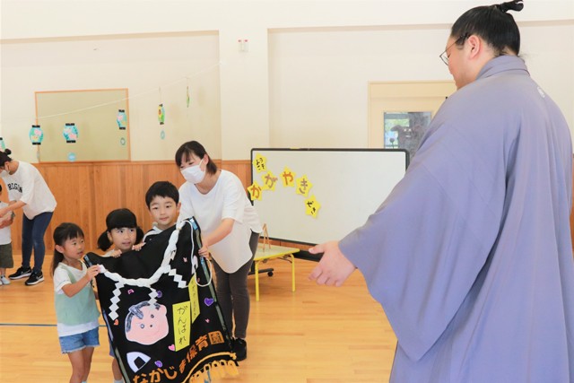 園児たちから化粧まわしを受け取る輝関