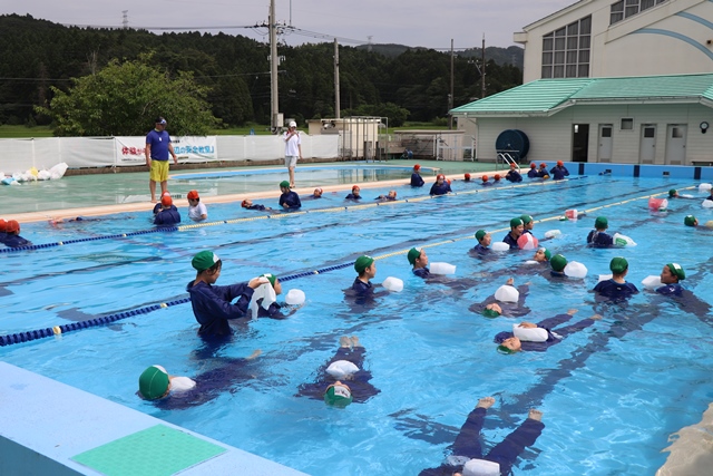 水面に浮かぶ練習をする児童たち