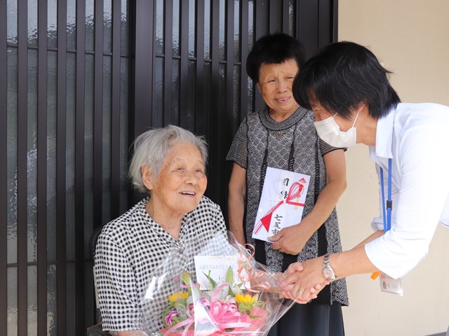 市から花かごを受け取るアサ子さん