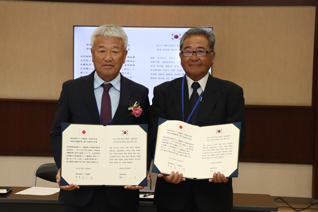 覚書を交わした春木会長と李院長