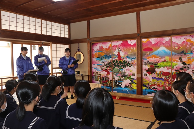 信行寺の襖絵を説明する高校生
