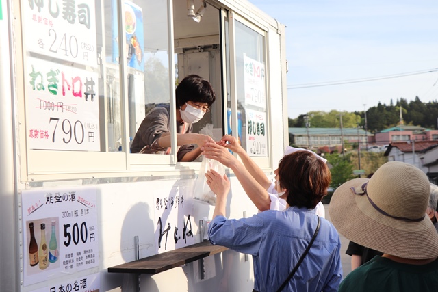 商品を手渡す店舗スタッフ