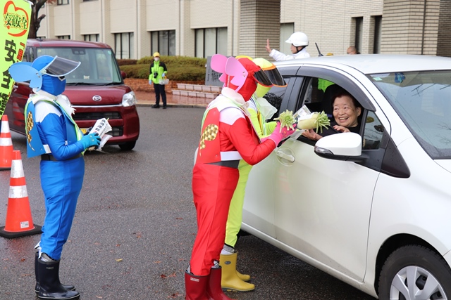 大根とグッズを手渡す様子