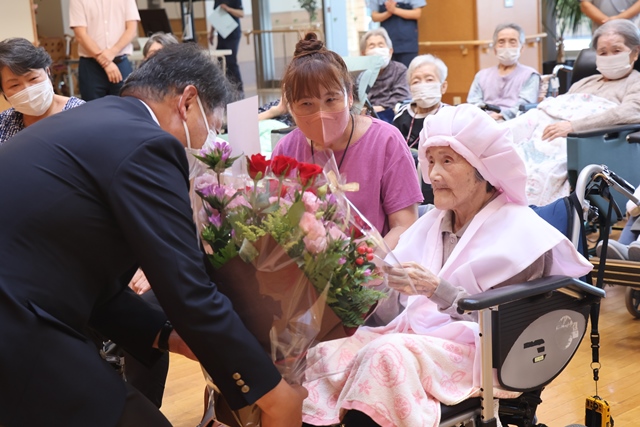 市長から花かごを受け取るかづ子さん