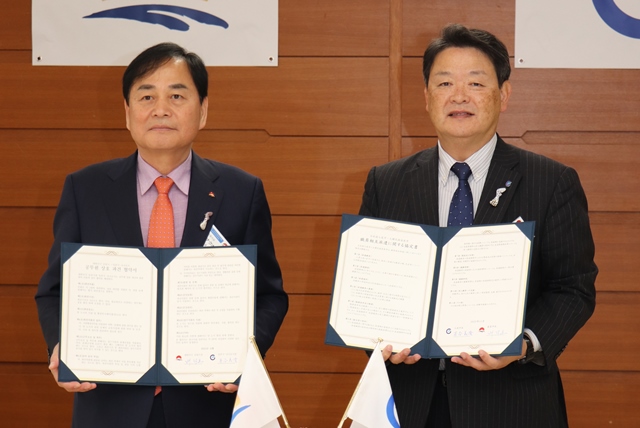 協定書を手にする両市長