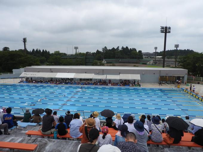 城山水泳プールで競技を見ている観客の写真